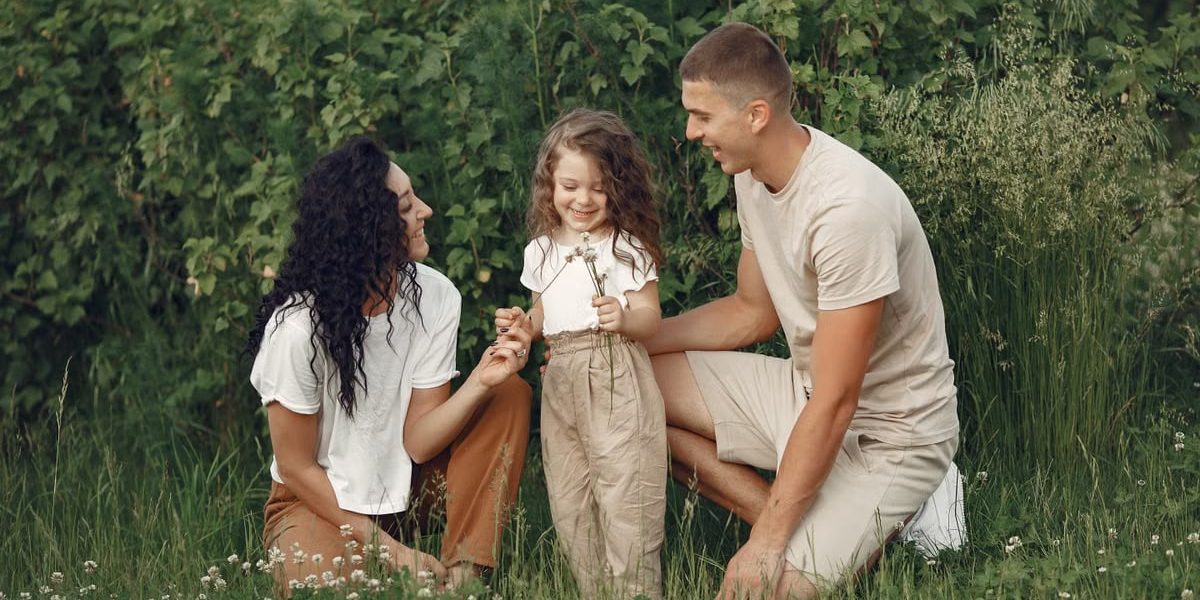 A joyful family enjoying time together in a lush green field.