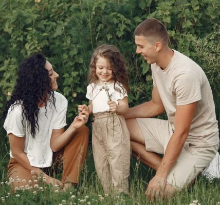 A joyful family enjoying time together in a lush green field.